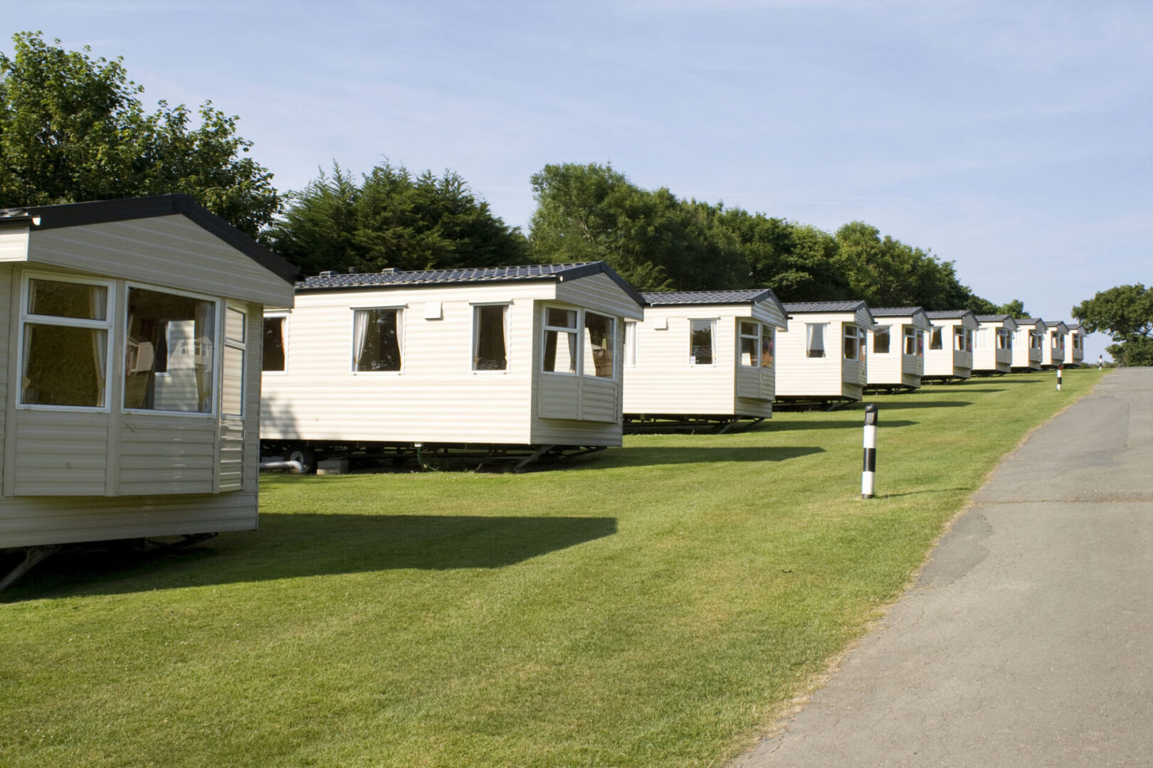 A row of mobile homes on the side of a road.